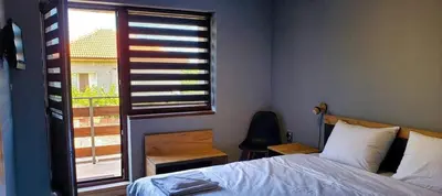 a bedroom with a bed and a window and a chair at Къща за гости “Приятели“ in Ovchartsi