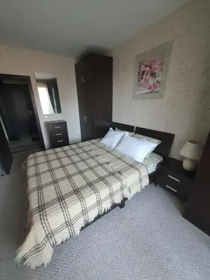 a bedroom with a bed with a plaid blanket on it at Green Life, Bansko, private property in the complex Paradiso Verde, apartman C23 in Bansko
