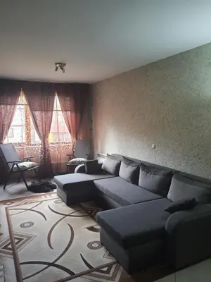 a living room with a couch and two windows at Green Life, Bansko, private property in the complex Paradiso Verde, apartman C23 in Bansko