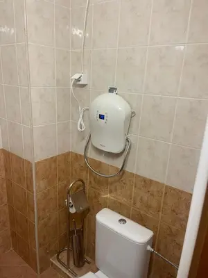 a bathroom with a toilet with a blow dryer on the wall at Borovets Sequoia2 Apartment no 5 in Borovets
