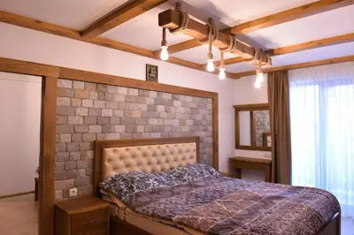 a bedroom with a bed and a brick wall at Лукс апартамент in Bansko