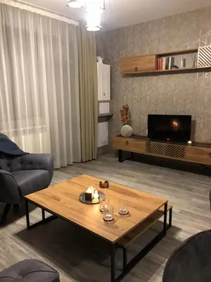 a living room with a coffee table and a tv at Luxury Aparthotel STUDENETS in Pamporovo