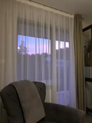 a living room with a couch and a window at Luxury Aparthotel STUDENETS in Pamporovo