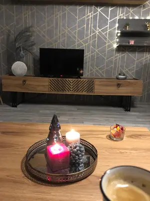 a candle on a tray on a table with a television at Luxury Aparthotel STUDENETS in Pamporovo