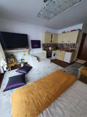 a bedroom with a large white bed with purple pillows at Vintage studio at Pirin golf in Bansko