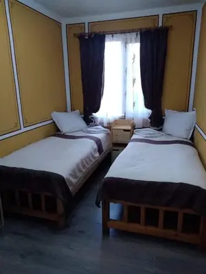 two beds in a room with a window at Тороманова къща in Koprivshtitsa