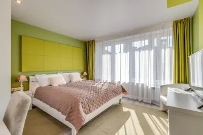 a bedroom with a bed and a large window at R & R Apartments in Sofia