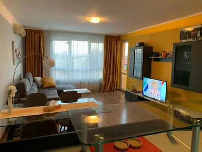 a living room with a couch and a tv at Central and Spacious apartment in Sofia