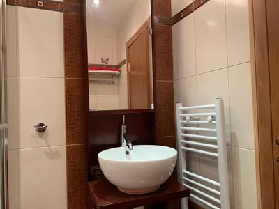 a bathroom with a white sink and a mirror at Central and Spacious apartment in Sofia