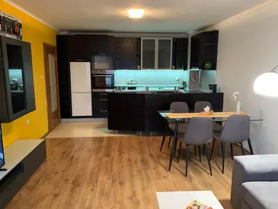 a kitchen and living room with a table and chairs at Central and Spacious apartment in Sofia