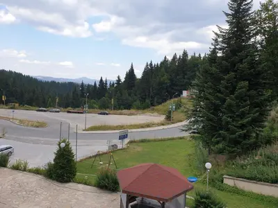 a park with a playground and a road with cars at Снежанка in Pamporovo
