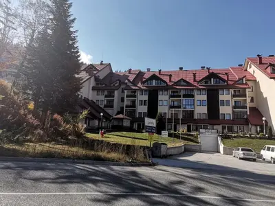 a large apartment building with a parking lot at Снежанка in Pamporovo