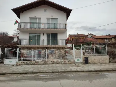 a white house with a fence in front of it at Стаи за гости РИЛА in Rila