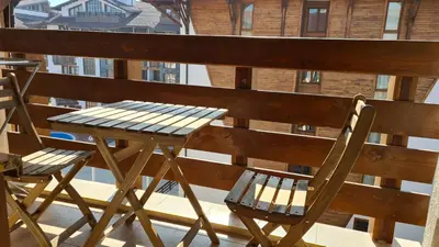 a wooden table and two chairs on a balcony at Luxury Apartment in Belvedere Club Hotel in Bansko