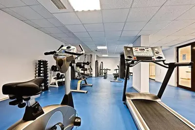 a gym with several treadmills and machines in it at Luxury Apartment in Belvedere Club Hotel in Bansko