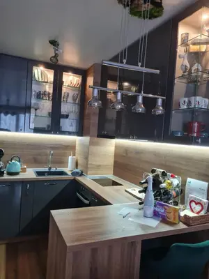 a kitchen with black cabinets and a wooden table at Mountain Paradise in Aparthotel Borovets Gardens in Borovets