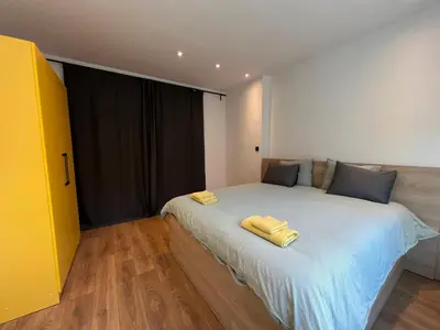 a bedroom with a bed with two yellow towels on it at HOME 12 in Sofia