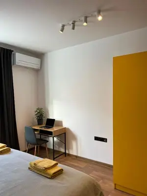 a bedroom with a bed and a desk with a laptop at HOME 12 in Sofia