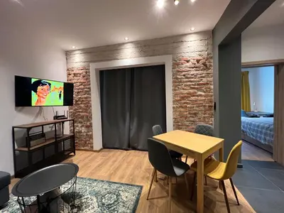 a living room with a table and chairs and a bedroom at HOME 12 in Sofia