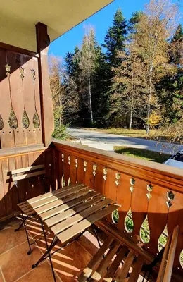 a wooden bench sitting on a porch with a window at KOKICHE 4 Friends, Borovets in Borovets