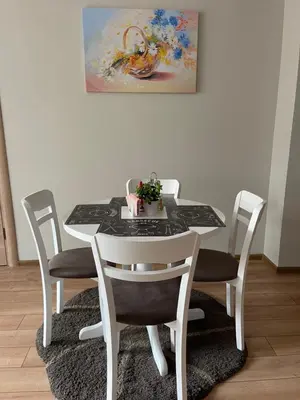 a white table and chairs with a painting on the wall at Nikol 2 Deluxe in Velingrad