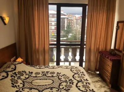 a bedroom with a bed and a window with a balcony at BREATHTAKING Mountain view 3 bedrooms appartement in Bansko