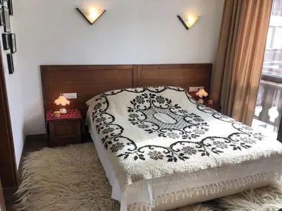 a bedroom with a bed with a black and white blanket at BREATHTAKING Mountain view 3 bedrooms appartement in Bansko