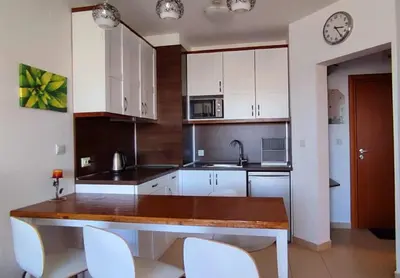 a kitchen with white cabinets and a wooden counter top at Bansko Belvedere Apartments in Bansko