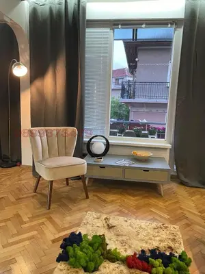 a living room with a chair and a window at Top center Art deluxe apartment near to Aleksander Nevsky cathedral in Sofia