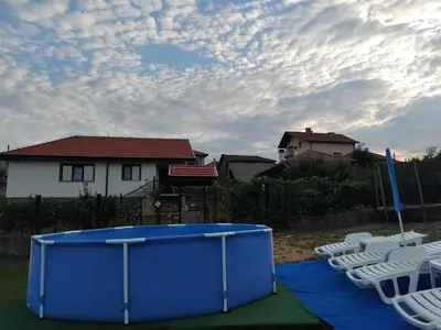 a group of lawn chairs and a blue tank at Къща за гости На Мечка in Oborishte