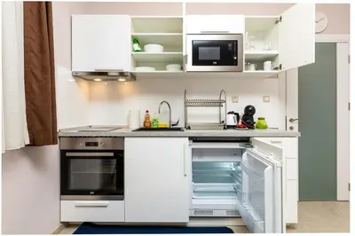 a kitchen with white cabinets and an open dishwasher at Stella 1&2 - Pink and Grey Studios near the Singing Fountains by Flat Mаnager in Plovdiv