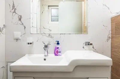 a white bathroom with a sink and a mirror at Stella 1&2 - Pink and Grey Studios near the Singing Fountains by Flat Mаnager in Plovdiv