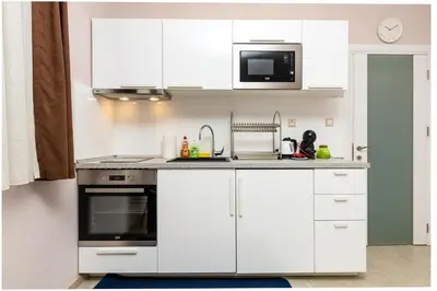 a kitchen with white cabinets and a stove and microwave at Stella 1&2 - Pink and Grey Studios near the Singing Fountains by Flat Mаnager in Plovdiv
