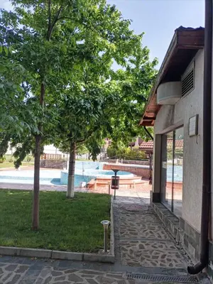 a building with a tree next to a swimming pool at Belvedere Holiday Club 101 in Bansko