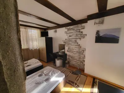 a room with a bed and a stone wall at Oasis Guest House in Dobrinishte