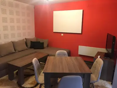 a living room with a couch and a table and chairs at Pamporovo Central Apartments in Pamporovo