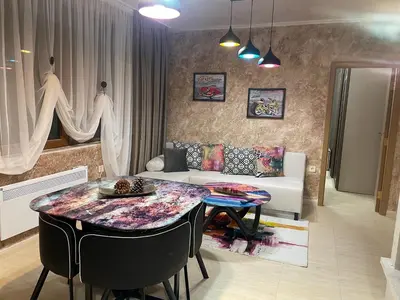 a living room with a table and a couch at Top of the Mountain Гранд Манастира частни Апартаменти in Pamporovo