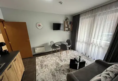 a living room with a table and chairs at MH Apartments in Bansko
