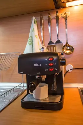 a black coffee maker on a counter with utensils at Cozy Colorful Studio at the foot of the Mountain by Flat Mаnager in Bansko