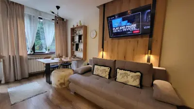 a living room with a couch and a tv at Pinewood ANG luxurious apartment A32 in Borovets
