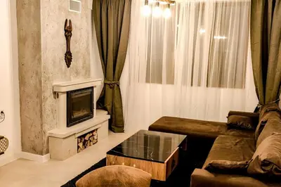 a living room with a couch and a fireplace at Луксозен Апартамент Мечи Чал - Апартхотел Манастира 2 in Pamporovo