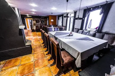 a dining room with a table and some chairs at Луксозен Апартамент Мечи Чал - Апартхотел Манастира 2 in Pamporovo