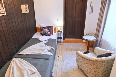 a bedroom with a bed and a chair in a room at 4 BDR House Monument of Culture & Architecture by Flat Mаnаger in Bansko