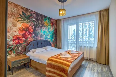 a bedroom with a bed and a floral wall at Colors of Nature in Stylish Flat in Pamporovo by Flat Mаnager in Pamporovo
