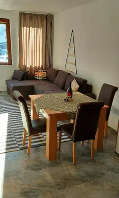 a living room with a table and a couch at BOGI SPA Apartment Pamporovo in Pamporovo