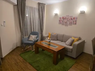 a living room with a couch and a table and a chair at Bansko Boutique Apartments - Flora Boutique in Bansko