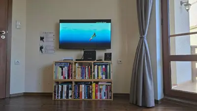 a television sitting on top of a book shelf with dvds at Bansko Boutique Apartments - Flora Boutique in Bansko