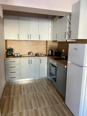 a kitchen with white cabinets and a tile floor at Apartment in Studenets, Pamporovo in Pamporovo