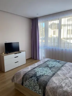 a bedroom with a bed and a flat screen tv at Apartment in Studenets, Pamporovo in Pamporovo