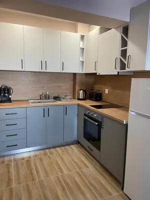 a kitchen with white cabinets and a sink and a refrigerator at Apartment in Studenets, Pamporovo in Pamporovo